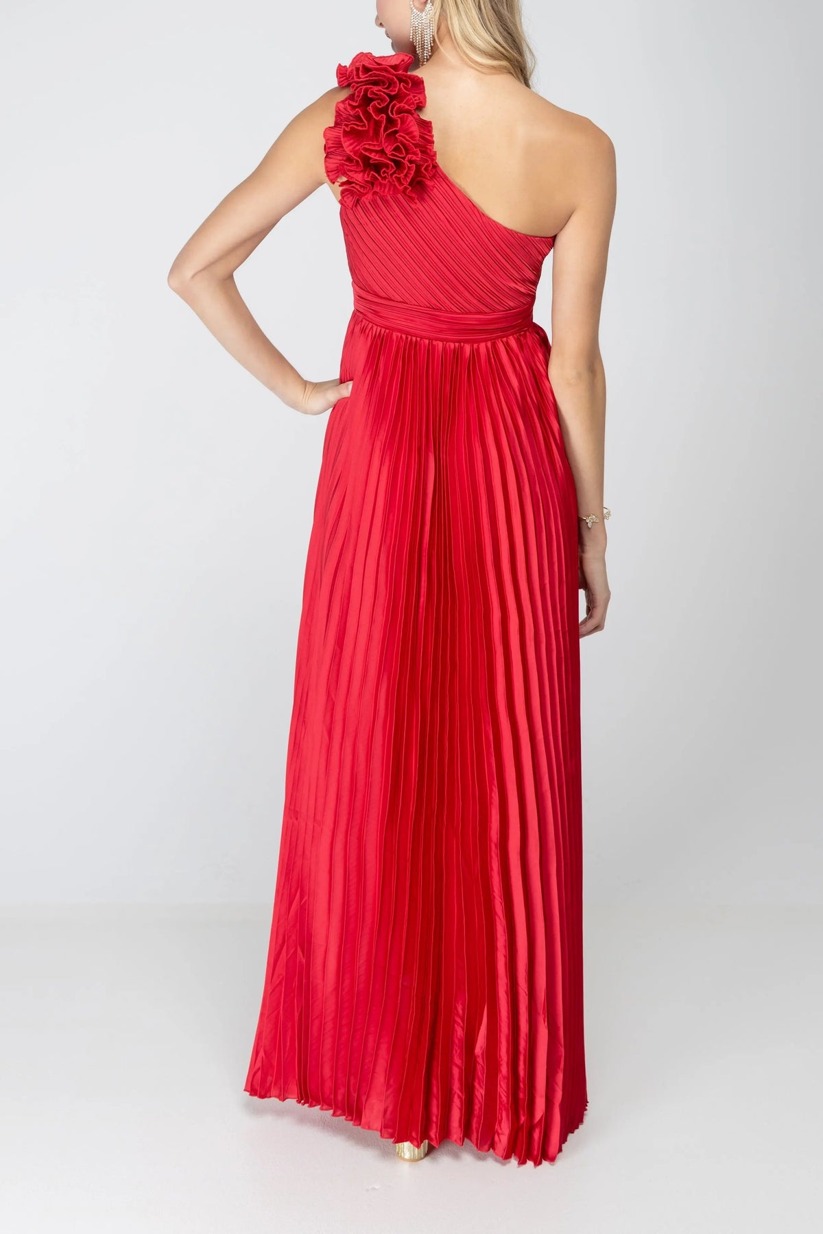 Back of the One More Night maxi dress in Red, showing the one-shoulder back, shoulder rosette and floor-length pleated skirt