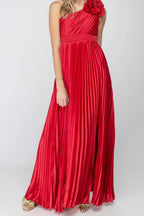 Front of the One More Night maxi dress in Red, showing the one-shoulder pleated satin bodice, ruffle rosette on the shoulder, banded waist and high leg slit