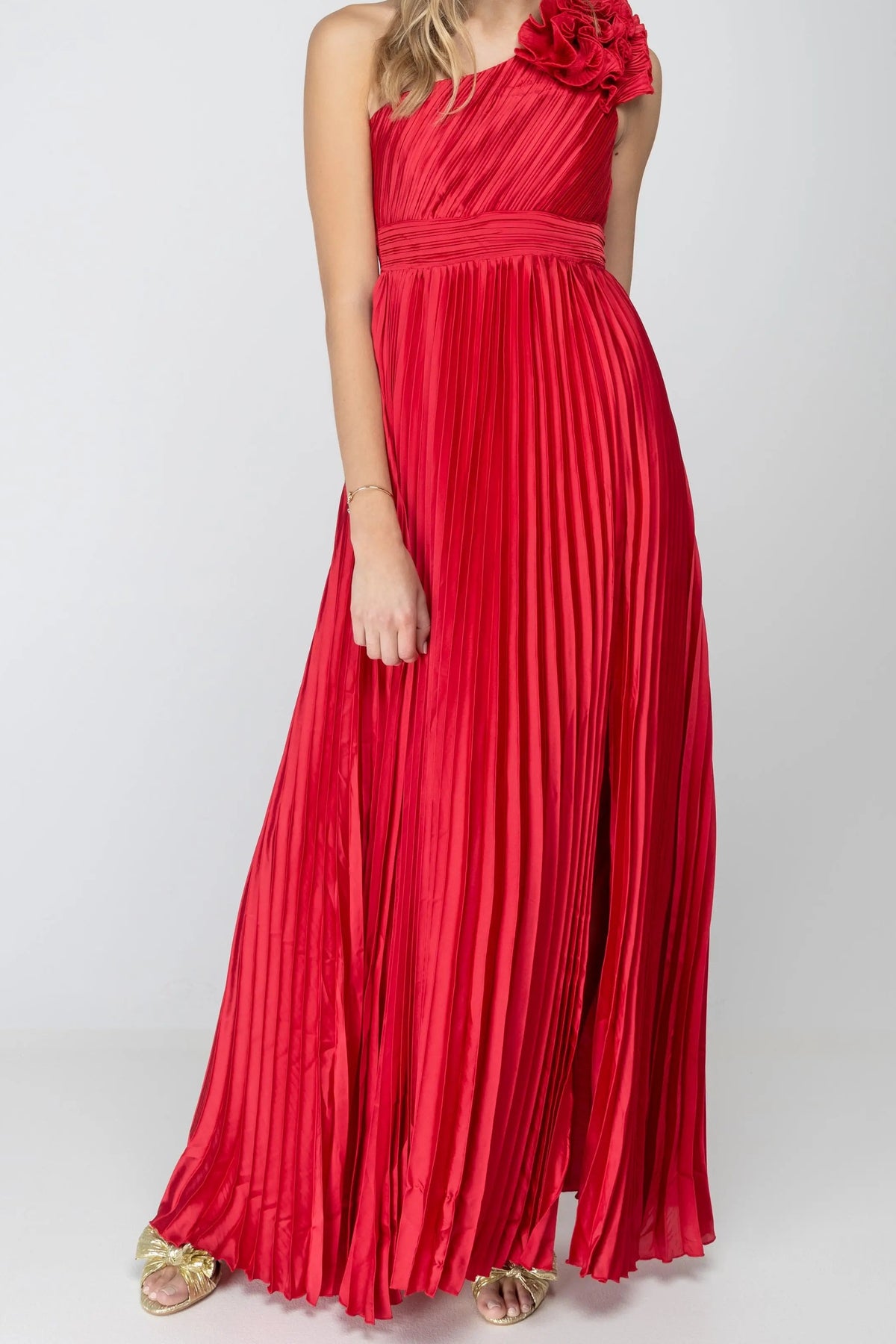 Front of the One More Night maxi dress in Red, showing the one-shoulder pleated satin bodice, ruffle rosette on the shoulder, banded waist and high leg slit