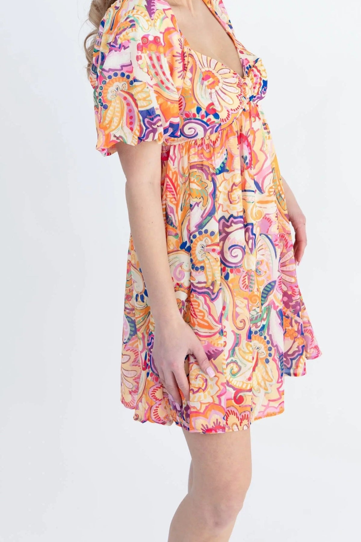 Side view of the Create Your Sunshine mini dress, showing the puff sleeve, empire waist and mid-thigh hem