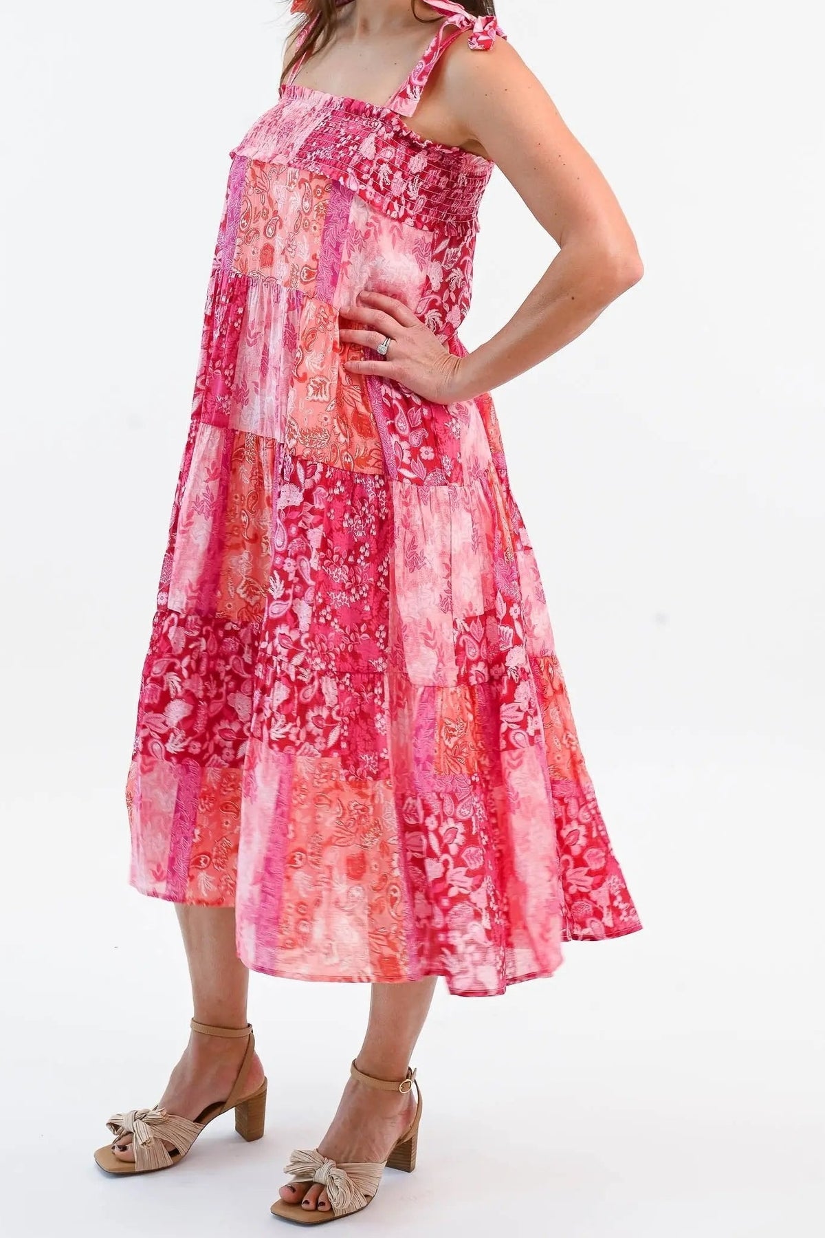 Side view of the pink patchwork shoulder-tie midi dress, showing the tiered skirt and mid-calf hem