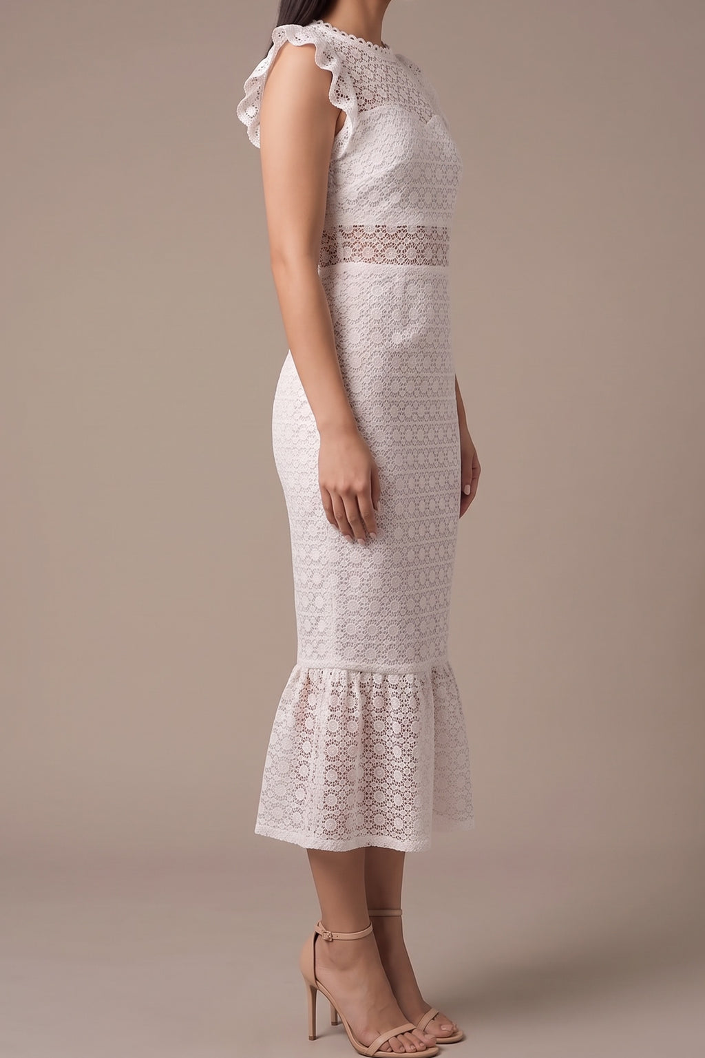 Side view of the white lace midi dress, showing the flutter cap sleeve, fitted body, sheer lace waist band and flounce hem at mid-calf