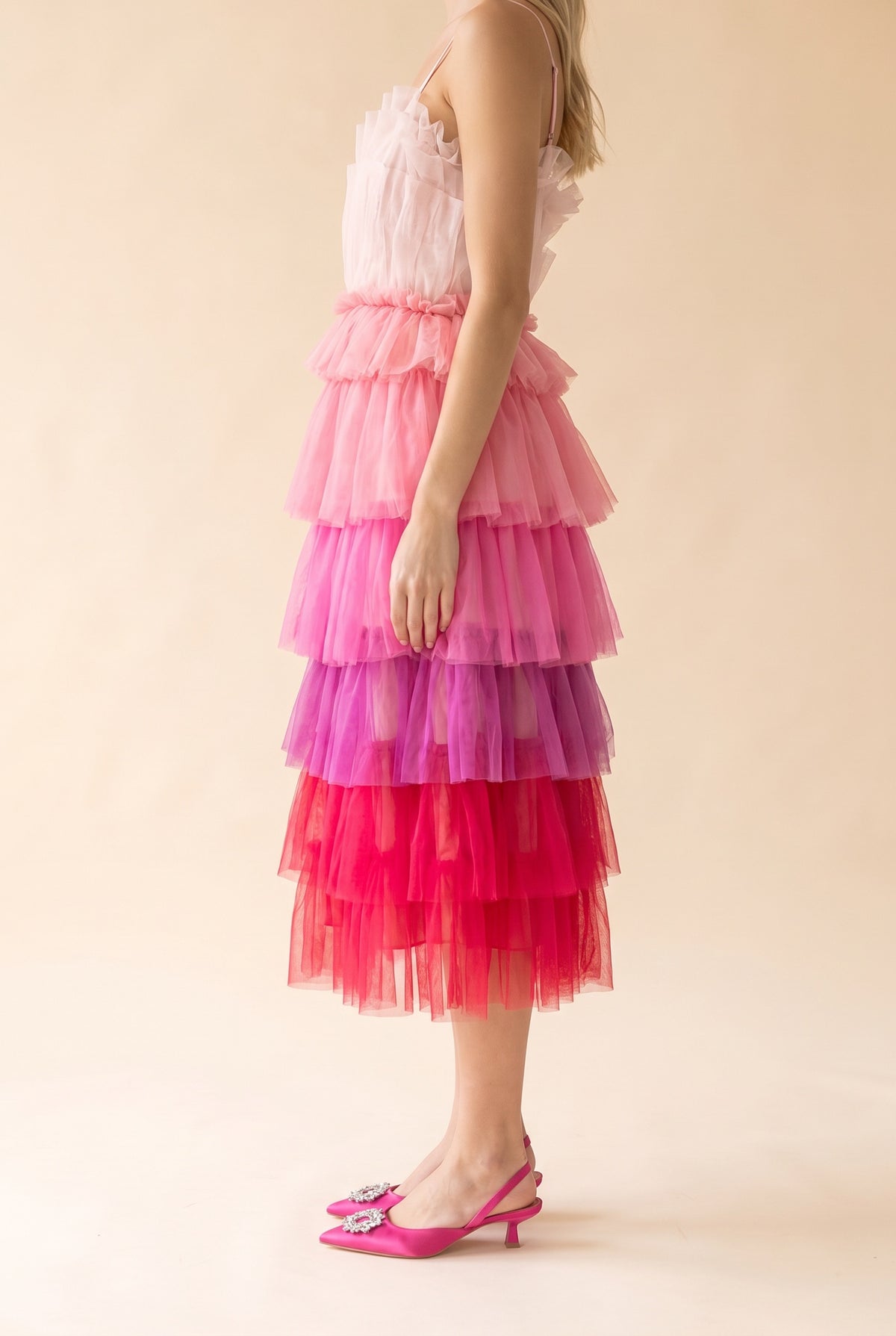 Side view of the pink ombre tulle midi dress showing the tiered ruffles from blush to raspberry and the mid-calf hem