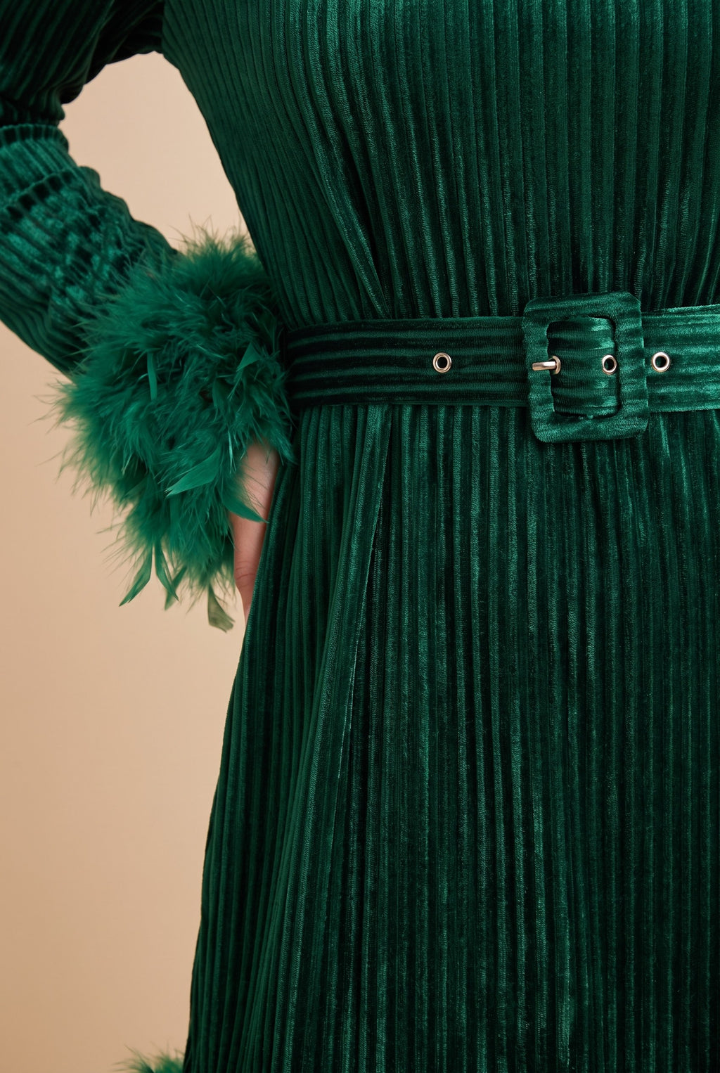 Close-up of the green velvet feather trim long sleeve mini dress, showing the velvet and the finishing details.