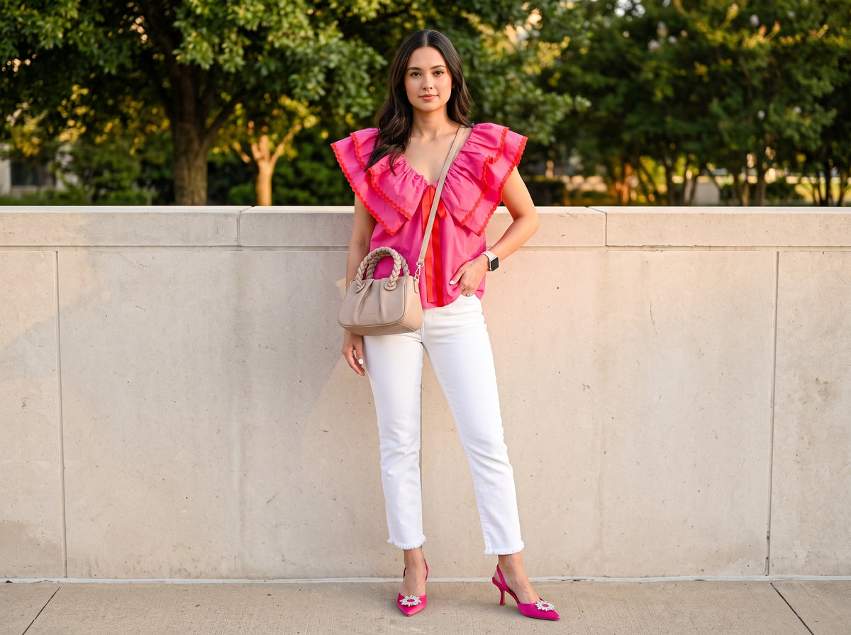 Woman in a pink ruffle babydoll top with white cropped jeans, pink satin slingbacks and a nude crossbody