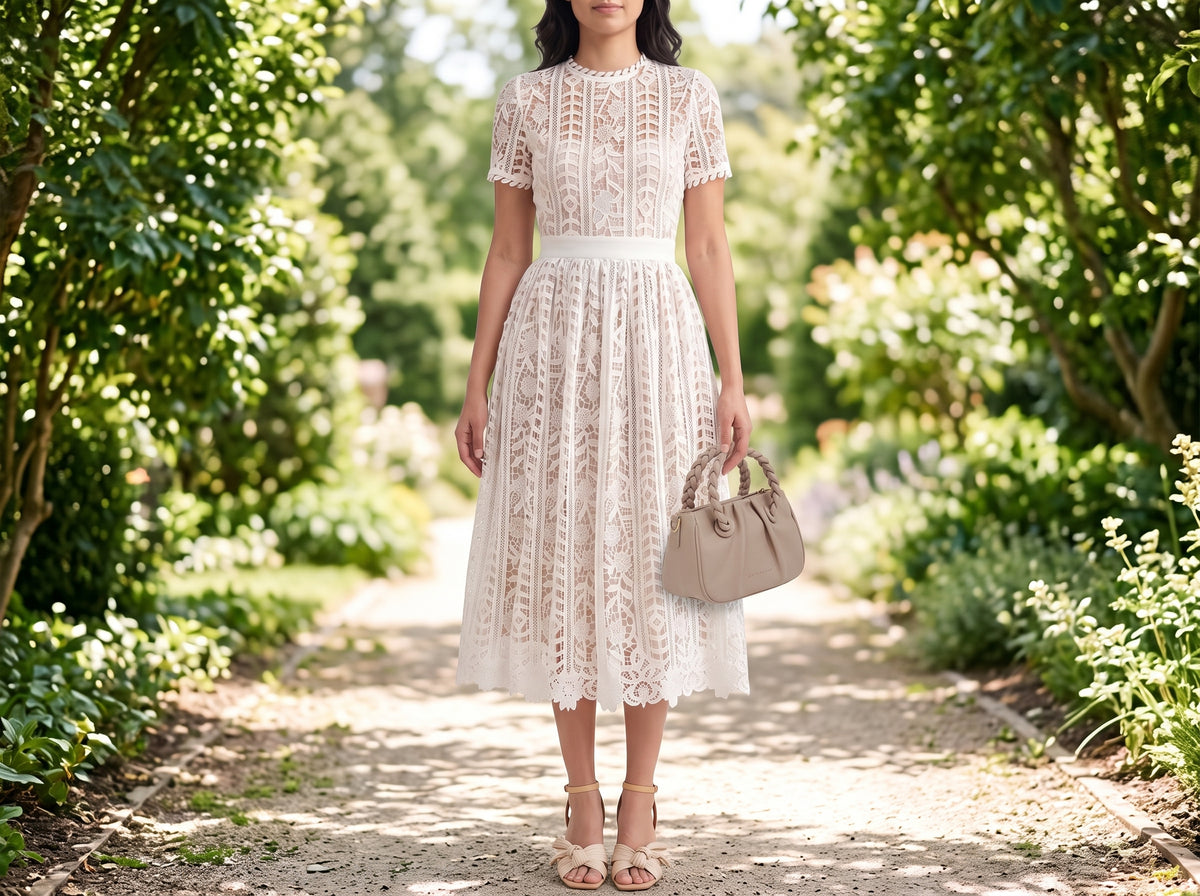 Woman in a short-sleeve lace midi dress with beige block-heel sandals, a beige braided crossbody bag and a gold pearl necklace