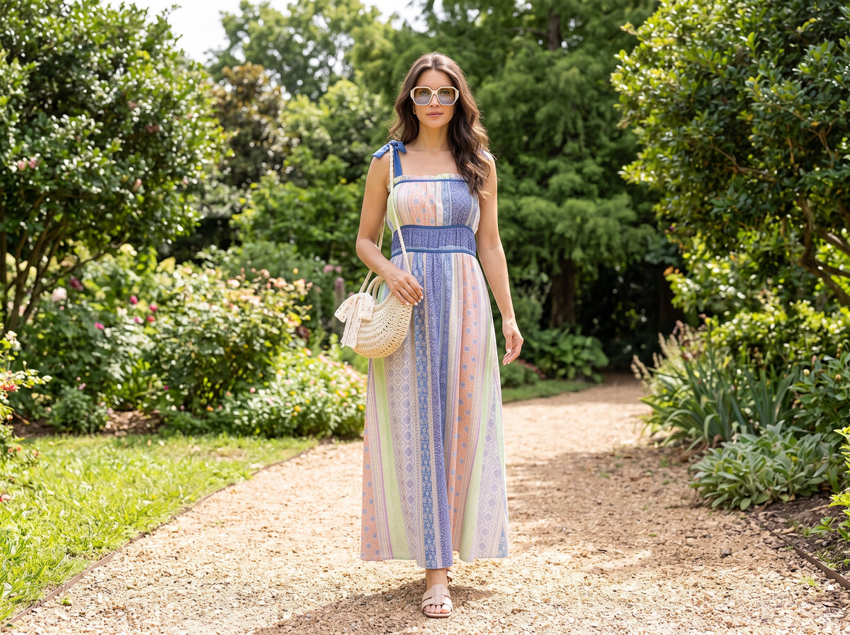 Woman in a sunny maxi dress with beige slide sandals, a straw crossbody bag and oversized sunglasses