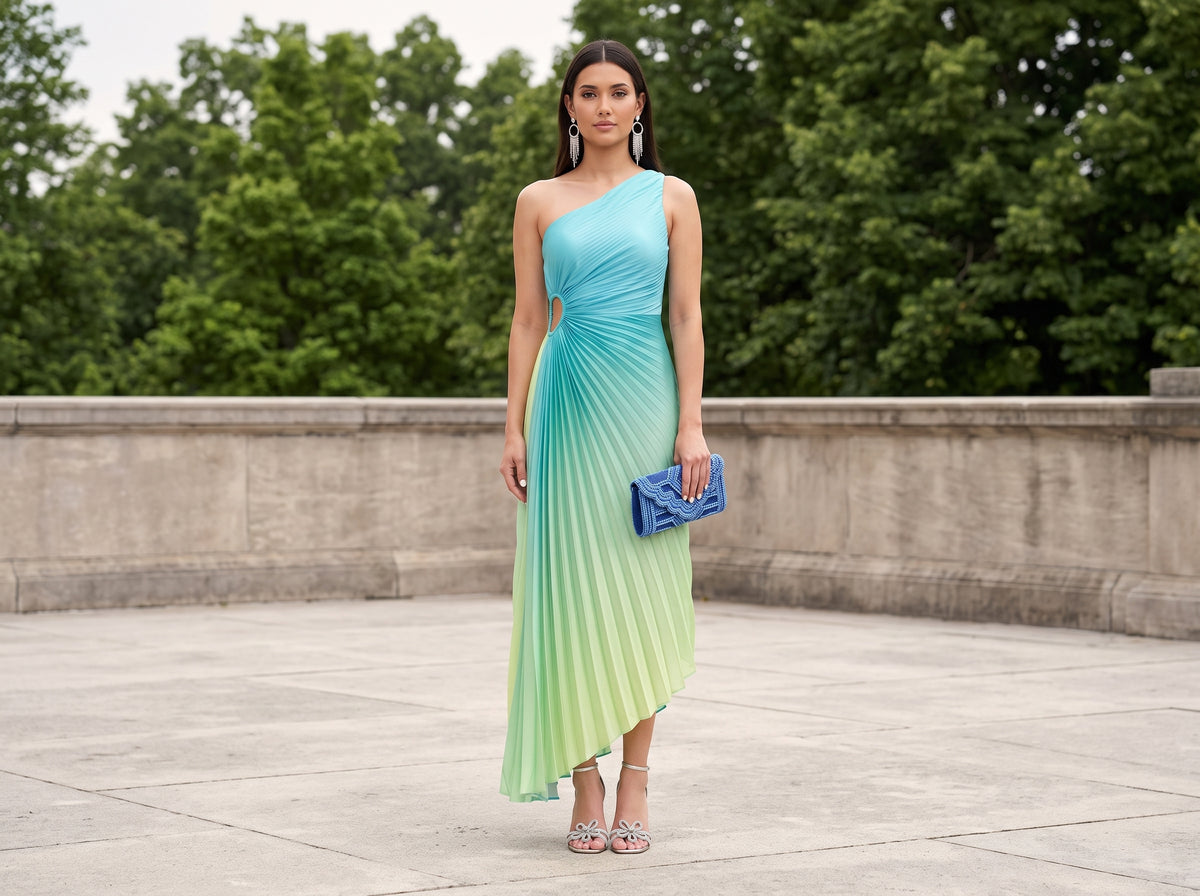 Woman in an ombre pleated one-shoulder maxi dress with silver sandals, a blue clutch and silver chandelier earrings