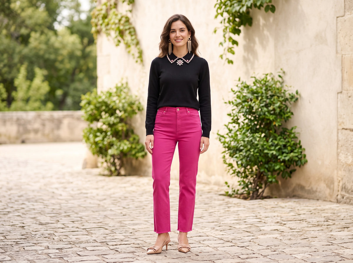 Woman in fuchsia straight pants with a black embellished sweater, nude pumps and gold fringe earrings