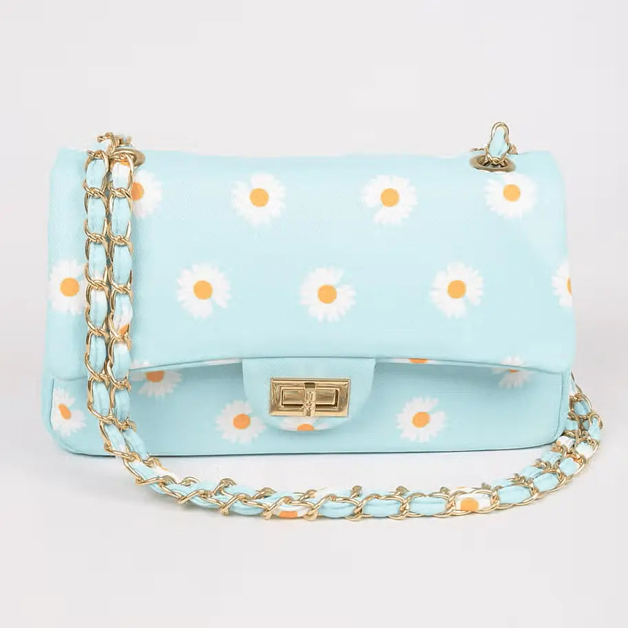 Sky-blue quilted daisy-print shoulder bag with gold chain strap and twist-lock closure.