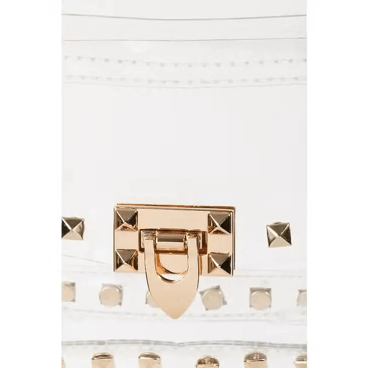 Clear studded crossbody bag with gold chain strap and twist-lock closure.